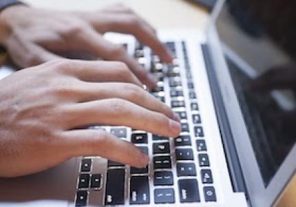 Fingers typing on a laptop
