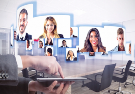 Multiple faces appearing in white pop-up frames across a board room to represent video conferencing technology